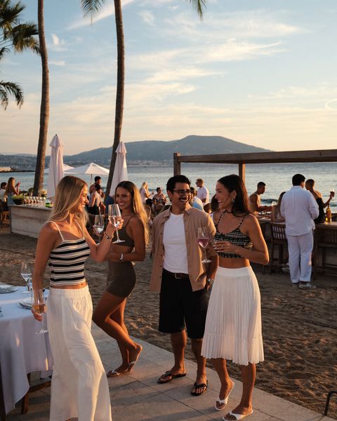 Freunde tanzen bei Sonnenuntergang in einer Strandbar